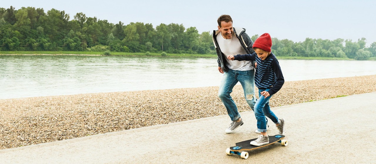 Mann und sein Kind auf dem Skateboard
