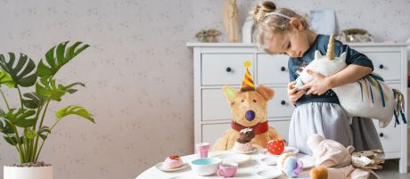 Kleines Mädchen spielt mit ihren Plüschtieren Teestunde